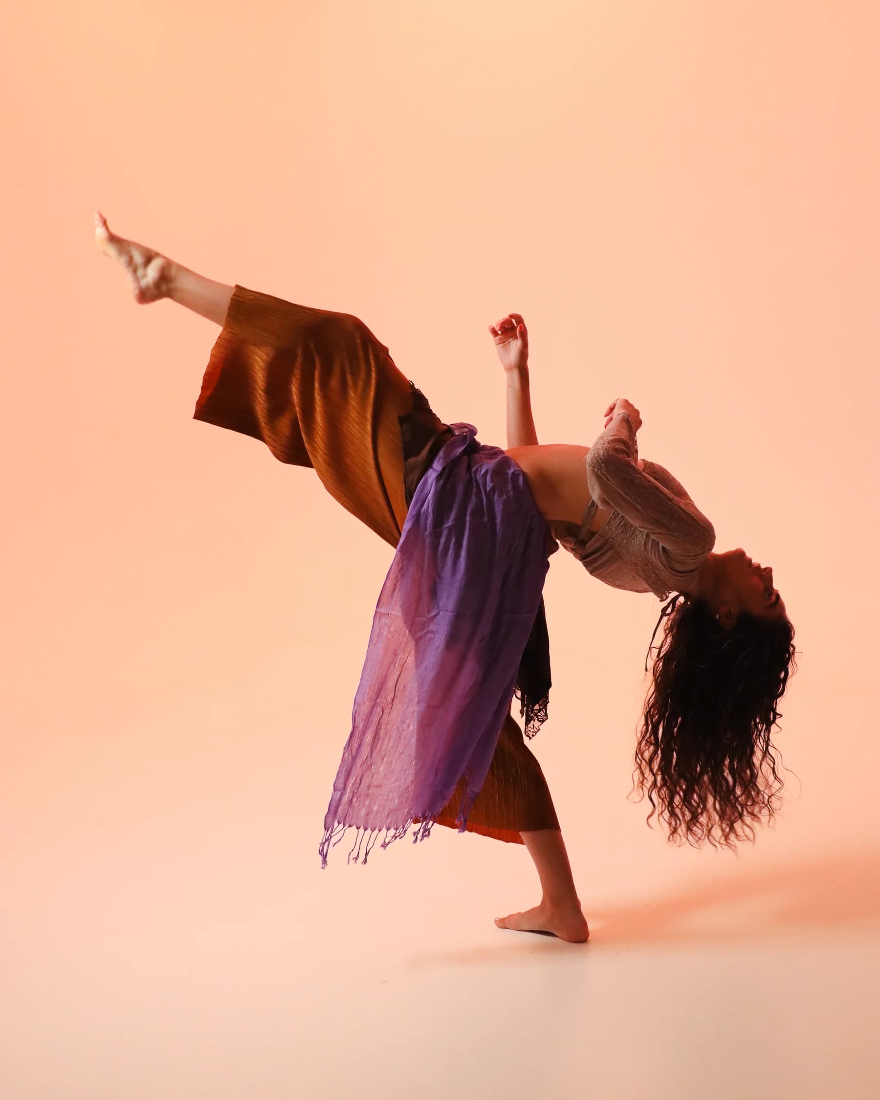 A dancer in a purple skirt bending backward through an open chest
