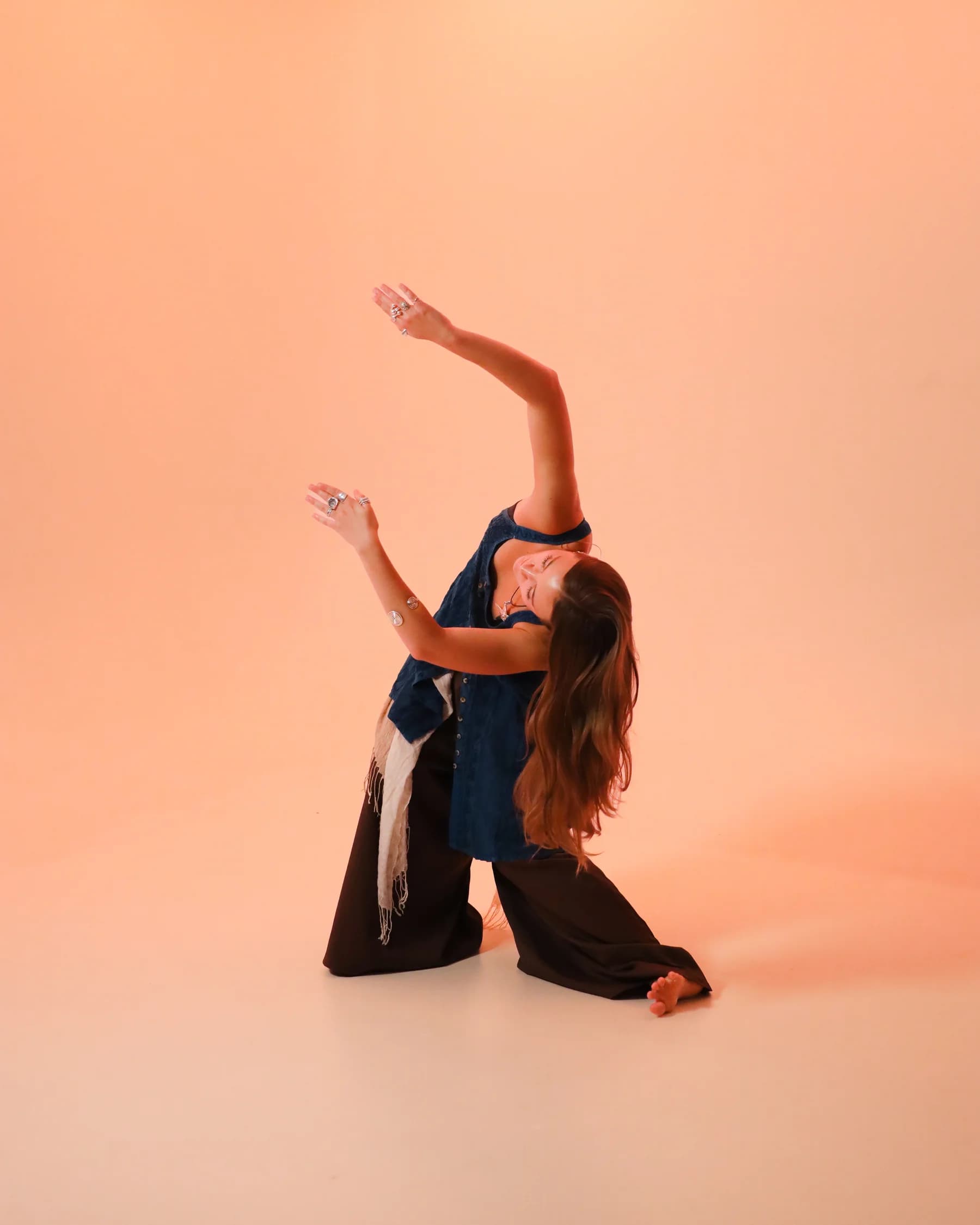 A dancer in blue folding through a grounded sideways reach