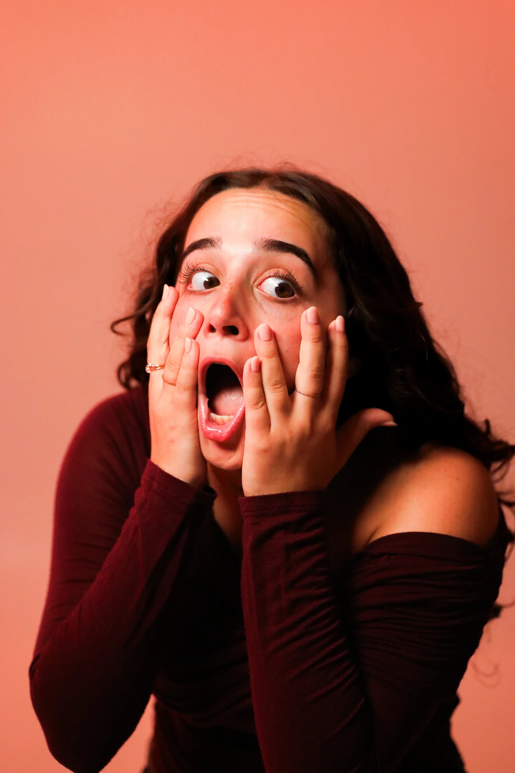 Expressive studio portrait of a dancer framing her face with both hands
